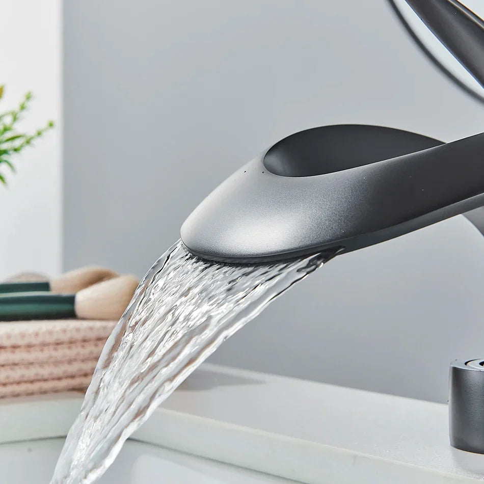 Grifo de lavabo tipo cascada DecorBites™ de latón negro, monomando para montaje en cubierta
