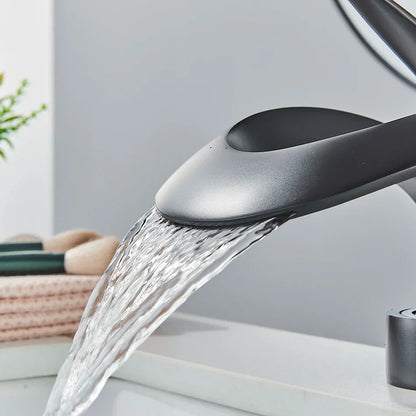 Grifo de lavabo tipo cascada DecorBites™ de latón negro, monomando para montaje en cubierta