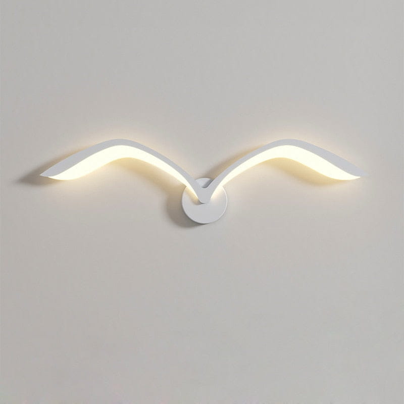 Modern white nordic avian style wall lamp designed as a seagull in flight with sleek curved wings emitting a warm glow for style indoor use.