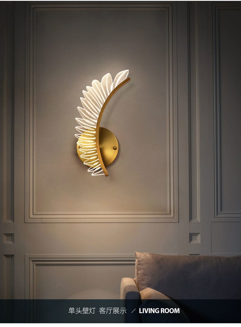 Gold-toned wall lamp featuring a white feather-like design in nordic modern art style for use as a modern art bedside sconce.