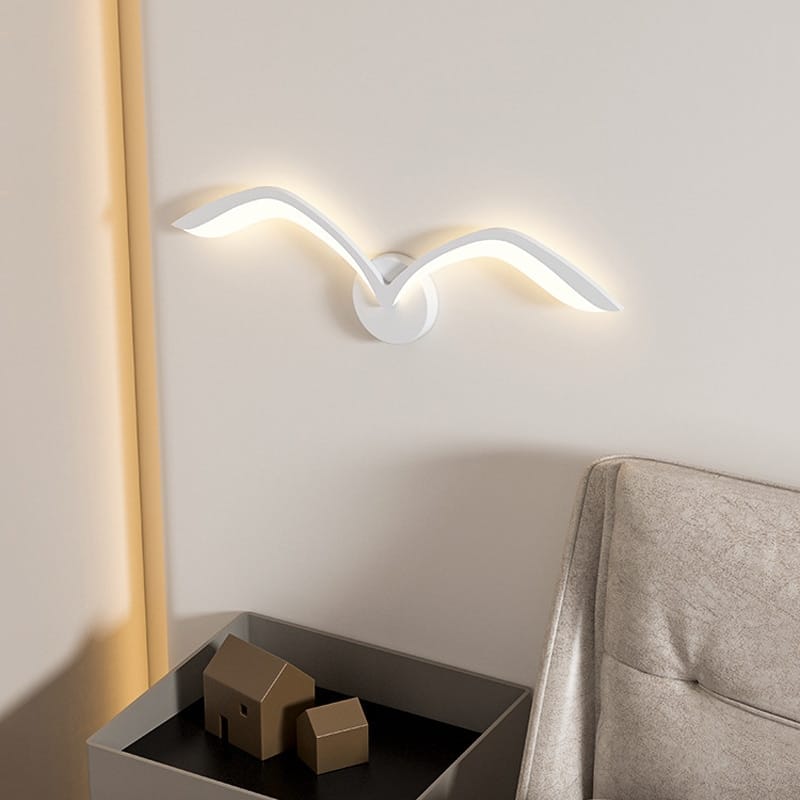 Modern white nordic avian style wall lamp shaped like a seagull with sleek design and warm ambient lighting for style indoor use in the bedroom.