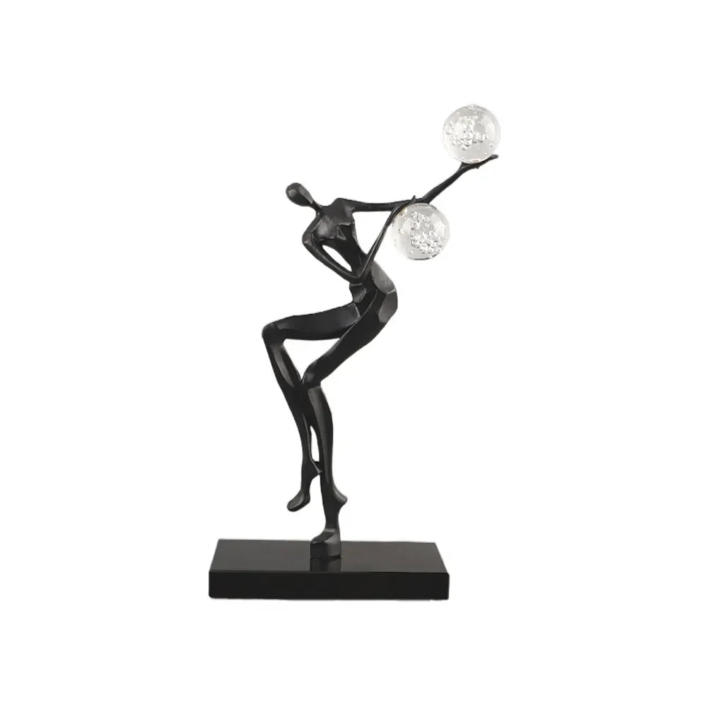 Figura escultórica acrobática de un hombre dorado bailando sobre una bola de cristal DecorBites™ para decoración del hogar
