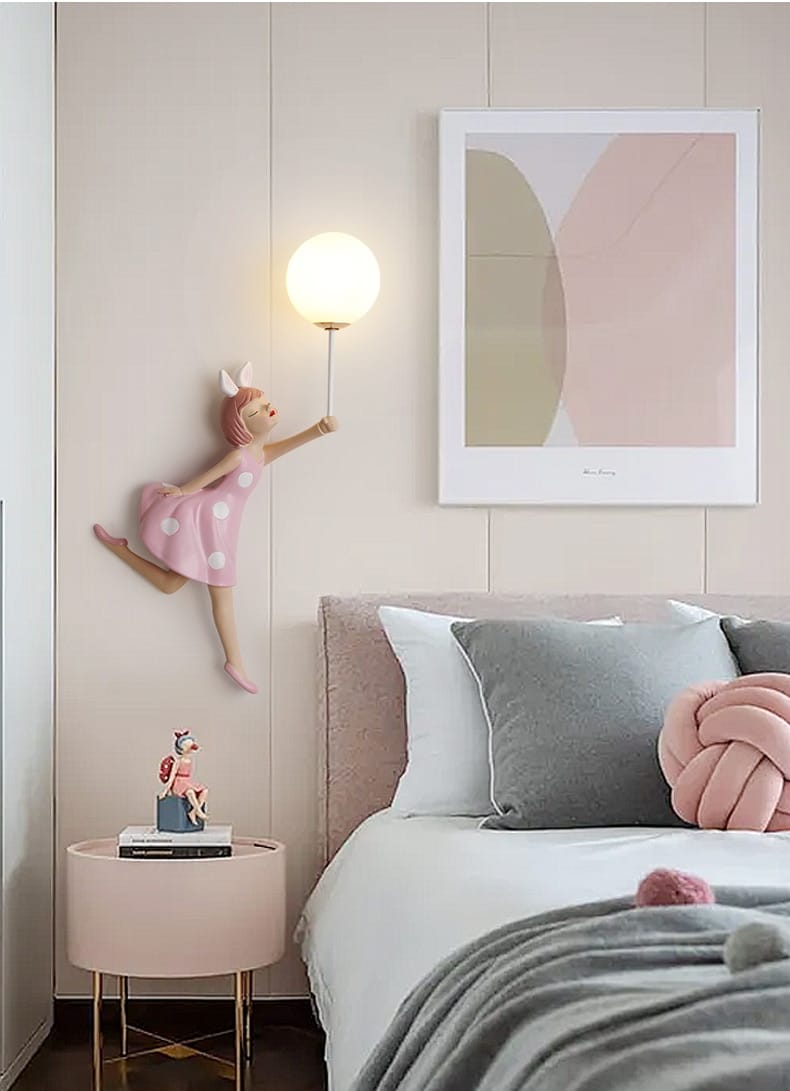 whimsical pink polka dot fairy girl wall lamp sculpture holding a spherical lamp suitable for bedroom decor.