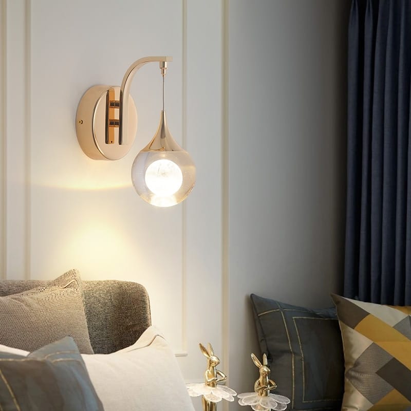 modern luxurious crystal led gold wall sconce with a curved arm and teardrop-shaped glass shade ideal for bedroom lighting