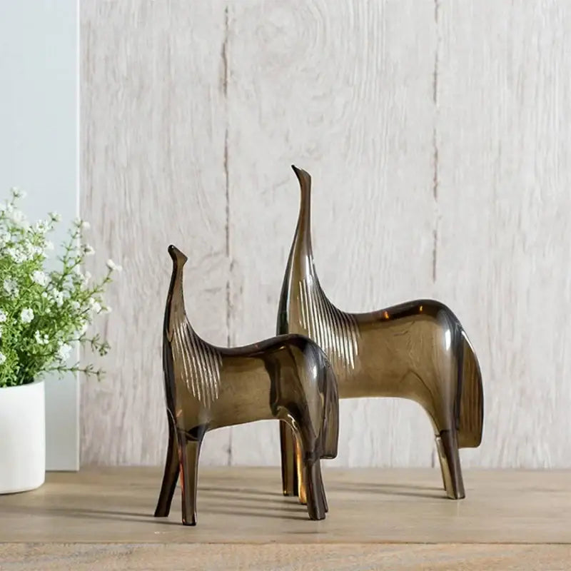 Two sleek amber glass horse couple figurines sculpture set on wooden surface for living room decor by decorbites horse couple