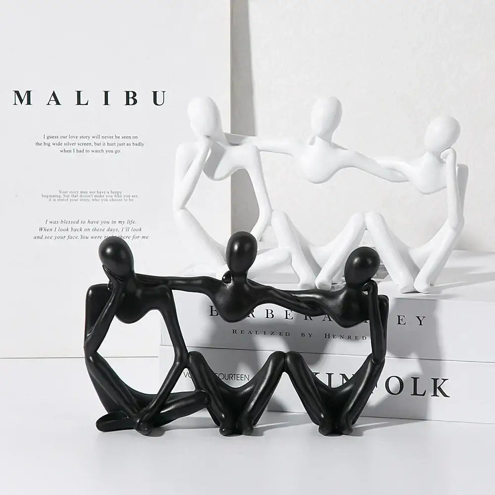 Black glossy abstract friendship figurine of three interconnected human figures in a seated pose for living room decor
