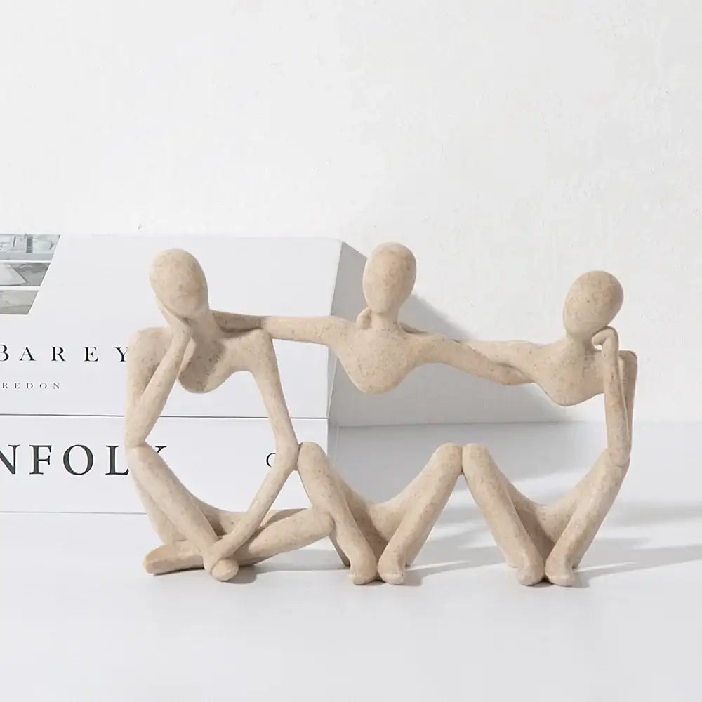 Beige ceramic abstract friendship figurine depicting three connected seated figures for living room decor