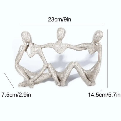 Gray speckled resin abstract friendship figurine of three human figures holding hands in a heart shape for living room decor