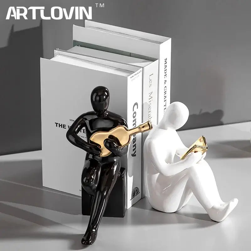 Abstract black and gold character bookends featuring a glossy black figurine holding a gold guitar in nordic decorbites style