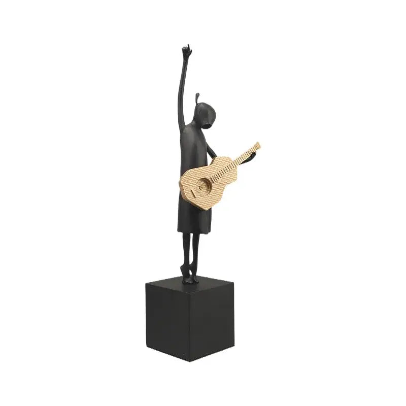 Abstract guitarist resin sculpture in black with gold guitar accents on a cube base for living room decor