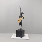 Abstract black and gold guitarist resin sculpture featuring a stylized girl figurine on a black cube base for decor