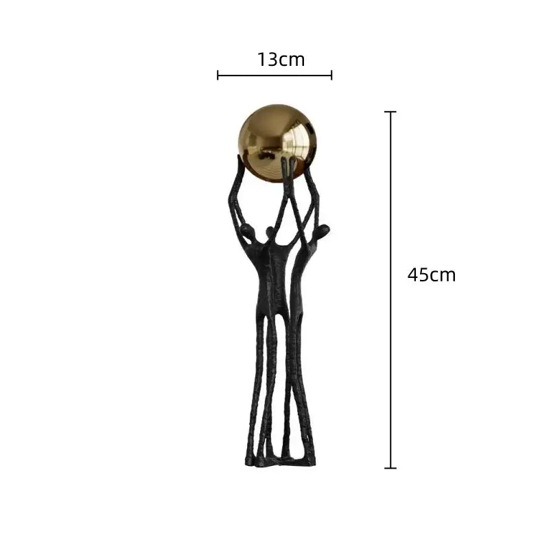 Abstract black and gold human figurine with three forms supporting a polished golden ball holder for living room decor