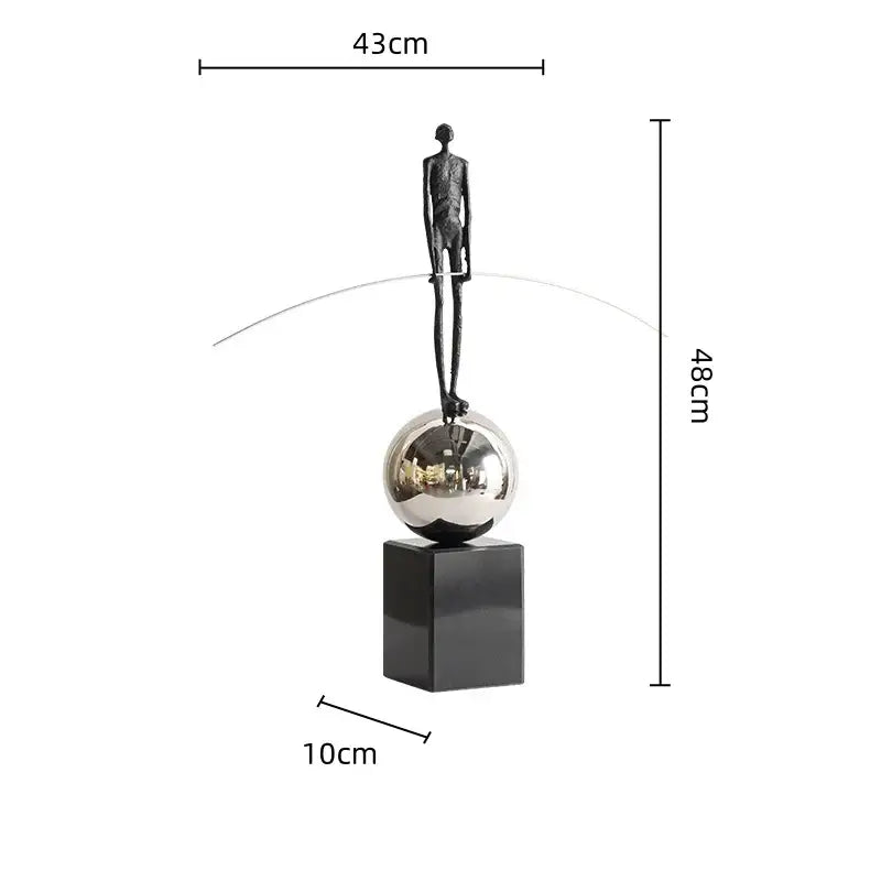 A sleek black metal human figure sculpture balancing on a silver sphere for living room decorbites decor