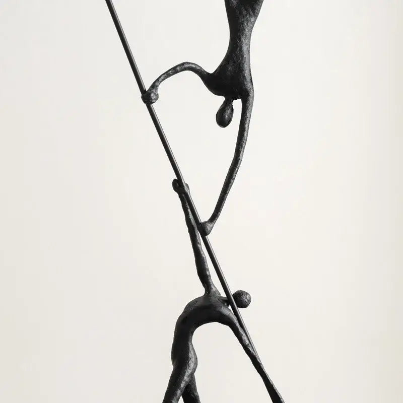 Abstract black and silver human figure sculpture with acrobatic figures balancing on thin pole for living room decorbites human figure decor