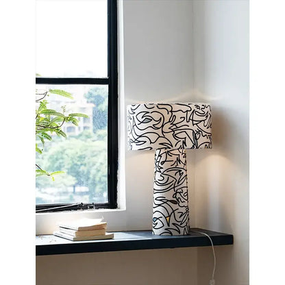 Modern study lamp with black abstract line art on white fabric base and shade from decorbites designer french medieval collection