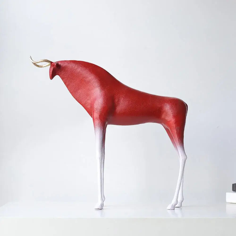 A sleek modern red and white bull sculpture with golden horns complementing abstract black and gold iron horse figurine decor