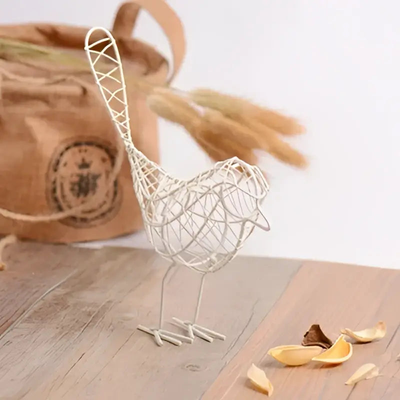 A delicate white decorbites iron bird figurine with woven mesh body and slender legs for living room decor