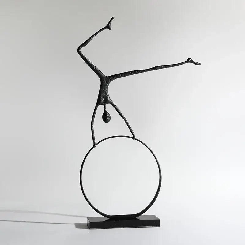 Abstract black metal sports figure sculpture by decorbites featuring a stylized human balancing on a circular ring