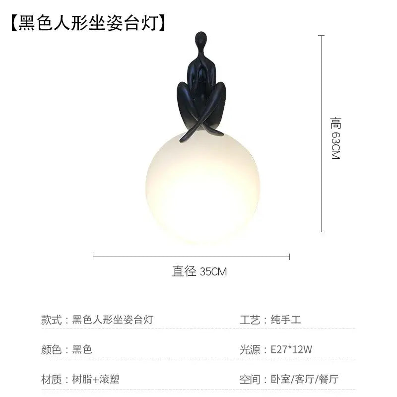 Abstract black ball holding character resin table lamp with glossy finish on spherical frosted glass base for living room