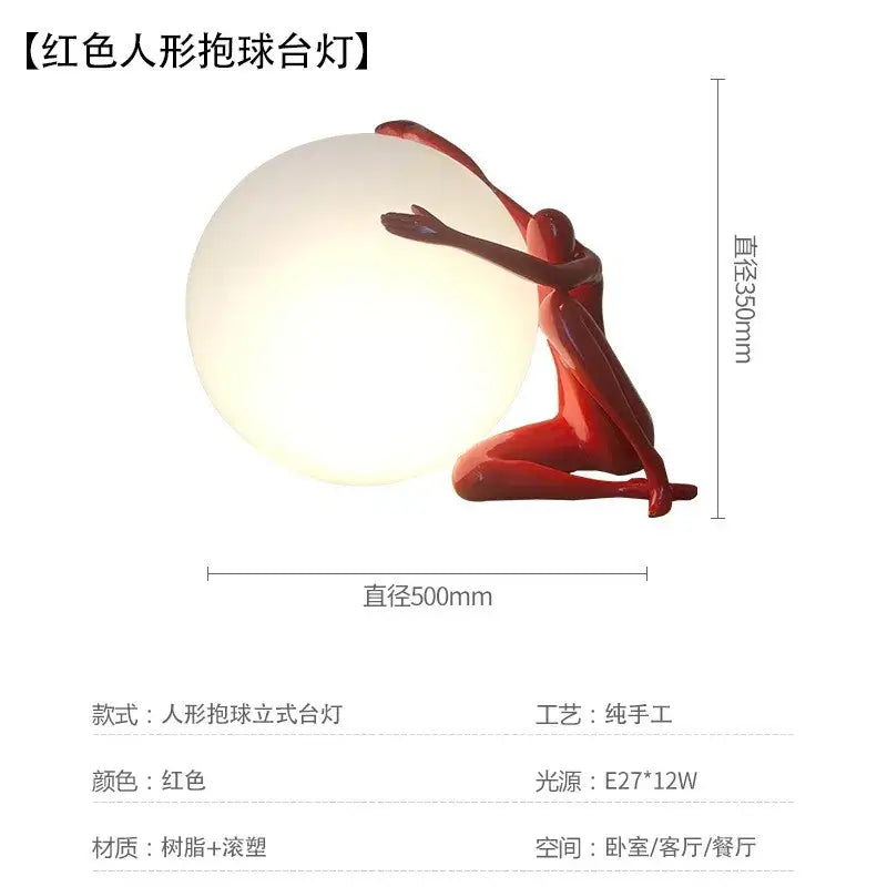 Red resin ball holding character figurine with glowing spherical lamp designed as artistic living room table light