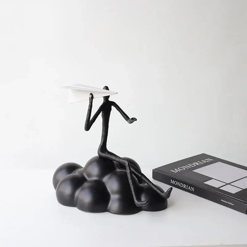 Abstract black resin paper airplane cloud figurine of stick-figure person holding white paper airplane for living room decor