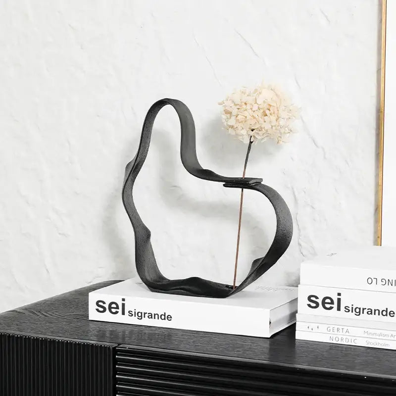Abstract black resin ring sculpture with metal vase holding dried white hydrangea for decorbites home decor