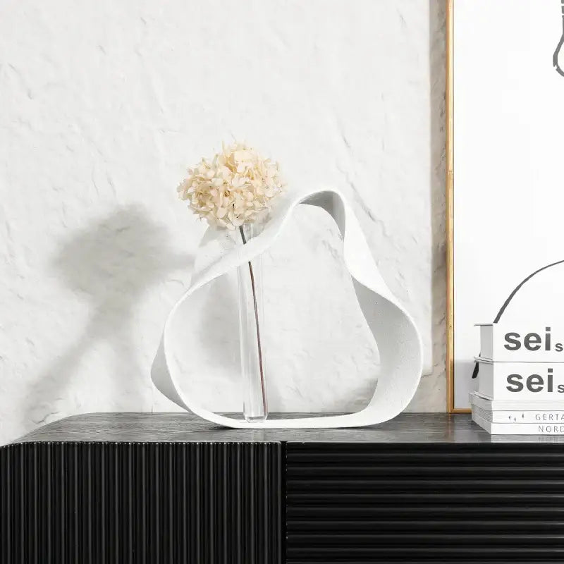 Abstract black resin ring sculpture with white ceramic vase and dried hydrangeas for modern home decor decorbites geometric