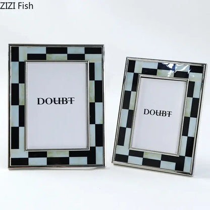 Two rectangular photo frames with black and white plaid mother-of-pearl inlay and silver-toned decorbites black white borders