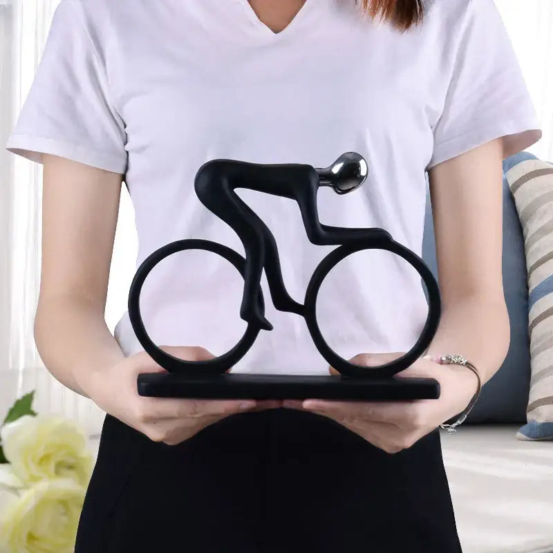 Black minimalist abstract resin cyclist statue with sleek design and polished metallic head for living room decorbites decor