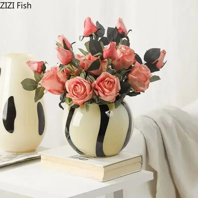 Cream-colored ceramic vase with bold black stripes holding pink roses perfect for decorbites black stripes decor