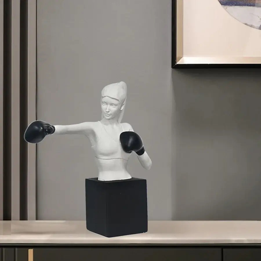 White resin boxer resin statue by decorbites featuring a female boxer mid-punch on a matte black base for living room decor