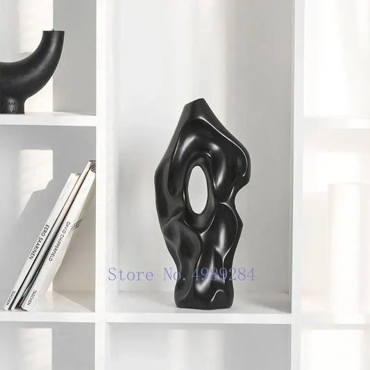 Black glossy abstract ceramic vase with organic flowing contours and central oval opening for living room decorbites decor