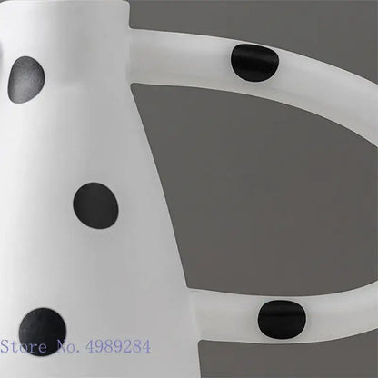 White bicycle frame with black circular accents complementing decorbites ceramic vase set with white spots for living room decor