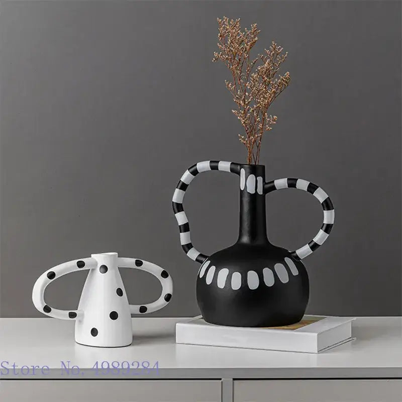 Abstract black and white ceramic vase set with white spots featuring striped handles and polka-dotted decorbites ceramic design