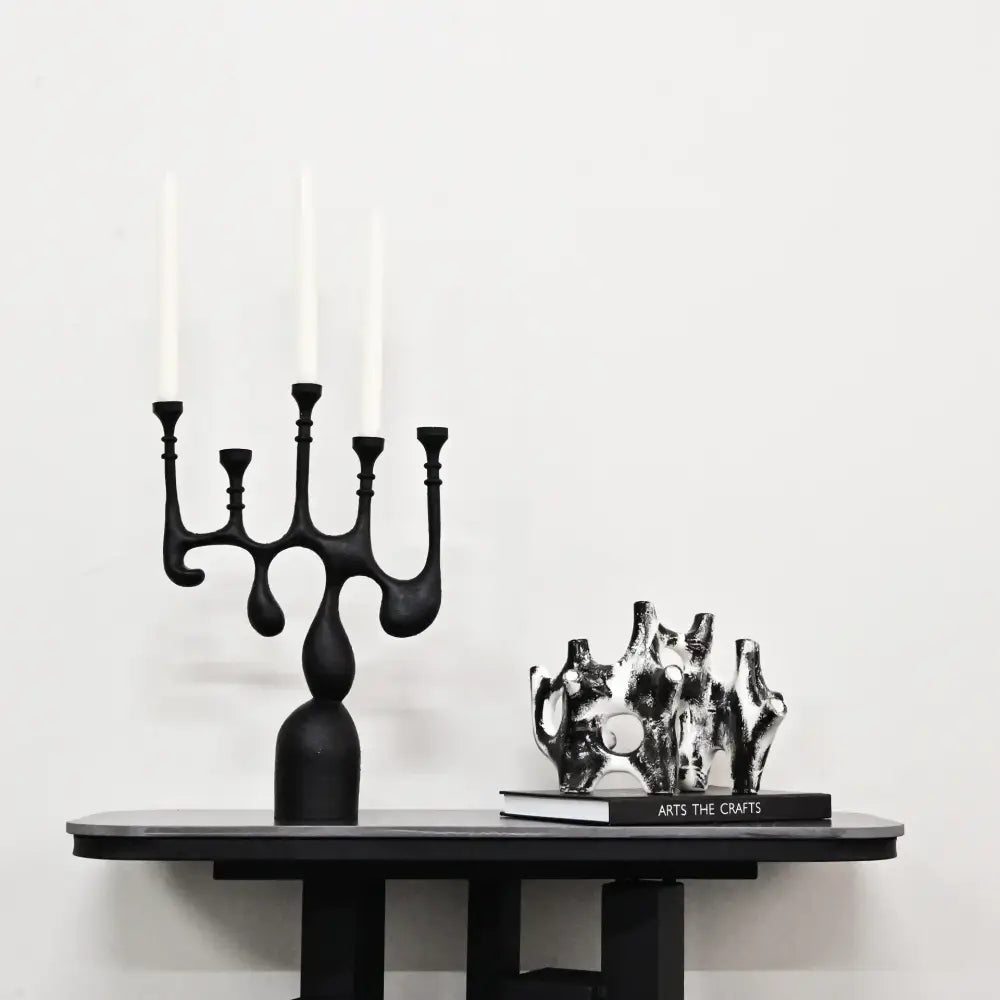 Black abstract candelabra with five slender arms and bulbous base coral reef piping home decor figurine