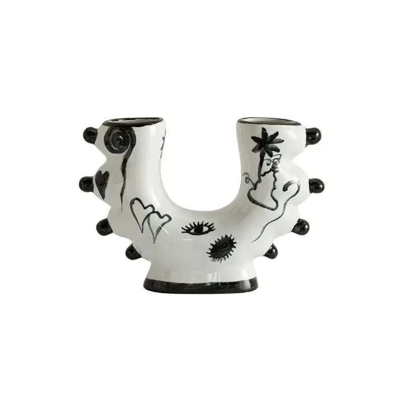 White ceramic u-shaped decorbites graffiti ceramic vase with black hand-painted eyes hearts and palm tree illustrations