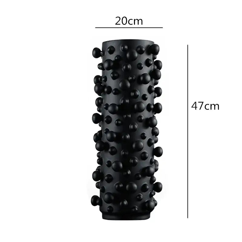 Black cylindrical foam roller with irregular bumps and rounded protrusions for decorbites black white living room decor