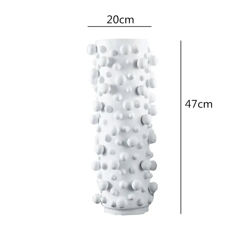 A tall white ceramic vase with irregular bumps features a black white abstract design for decorbites living room decor