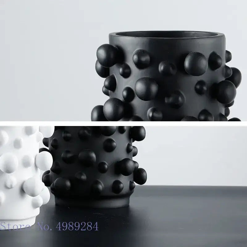 Black ceramic vase with irregular bumps and textured surface featuring black white abstract decorbites style design