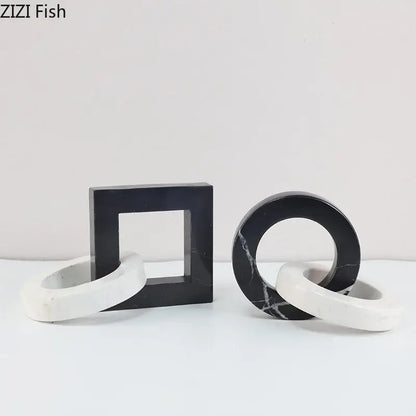 Black and white marble geometric knot bookends with abstract square ring design as a modern living room statue