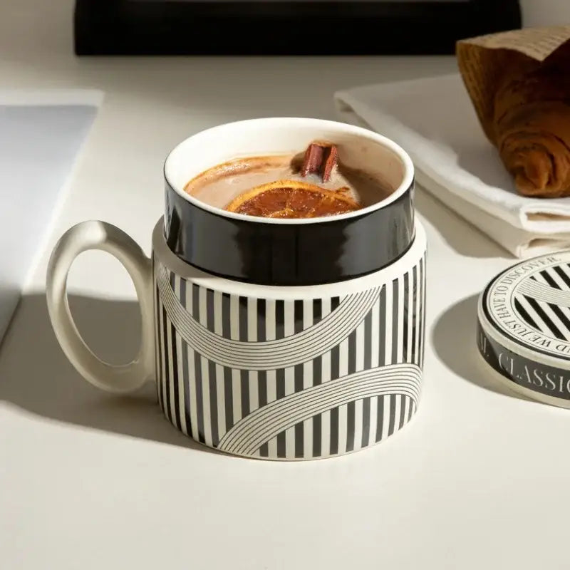 A black and white striped ceramic espresso cup with curved geometric patterns and a glossy finish for personalized french coffee gifts