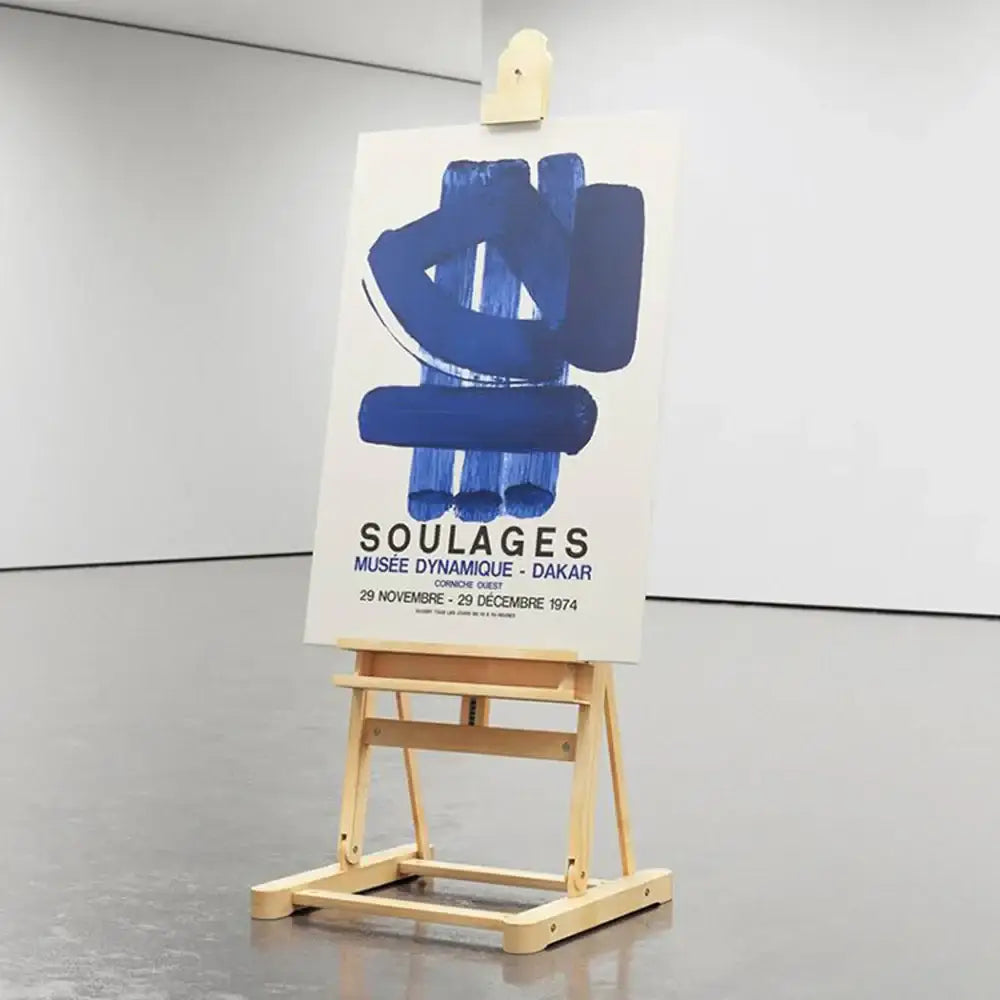 A bold blue abstract decorbites canvas painting on a wooden easel featuring soulages dakar exhibition art print details