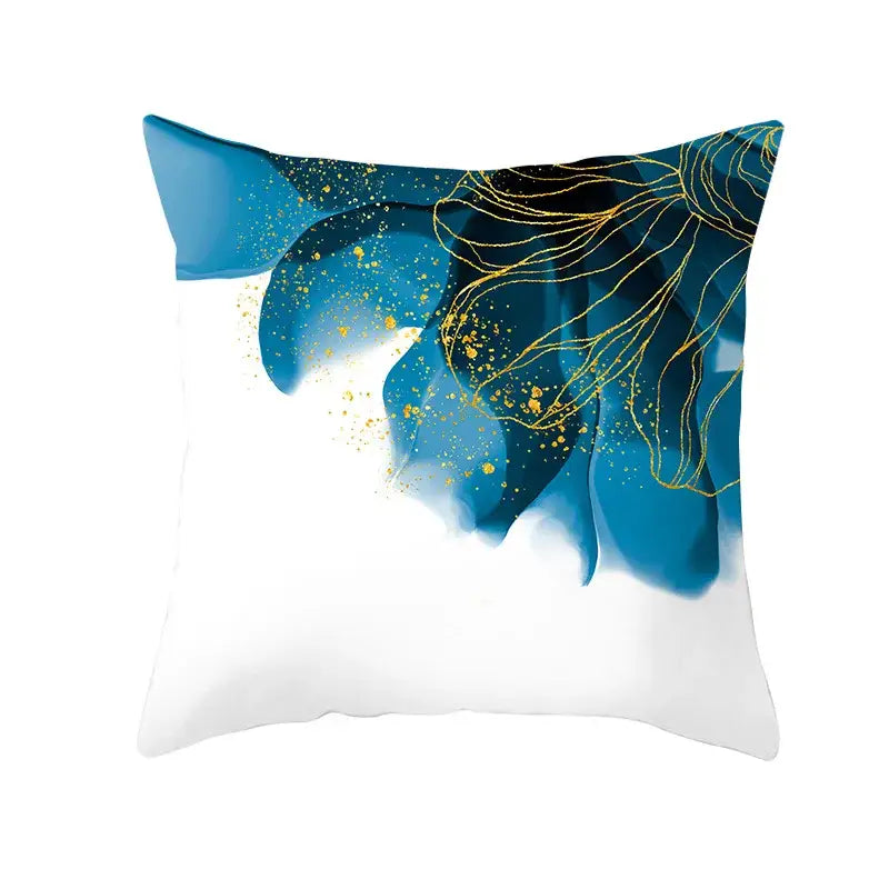 A square cushion cover featuring blue inkblot patterns with gold edge accents on a white background for living room use