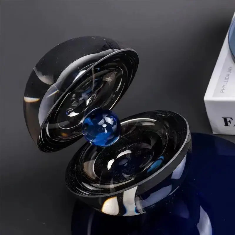 A sleek black glass semi-circle ornament with a vibrant blue crystal sphere for home decor by decorbites crystal glass