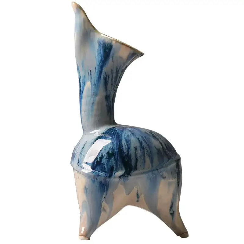 A ceramic vase with irregular blue and beige ink pattern glaze, tall slender neck, and three tripod legs for living room decor