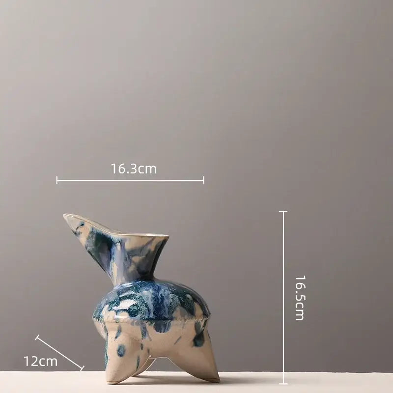 A ceramic vase with a blue and white glaze featuring an irregular ink pattern and an abstract tripod base for living room decor