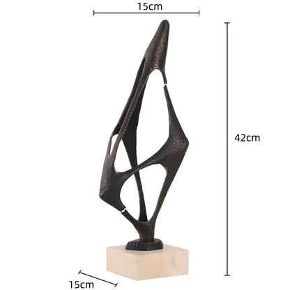 Abstract black metal geometric abstract face sculpture with textured oxidized finish on beige marble base for living room