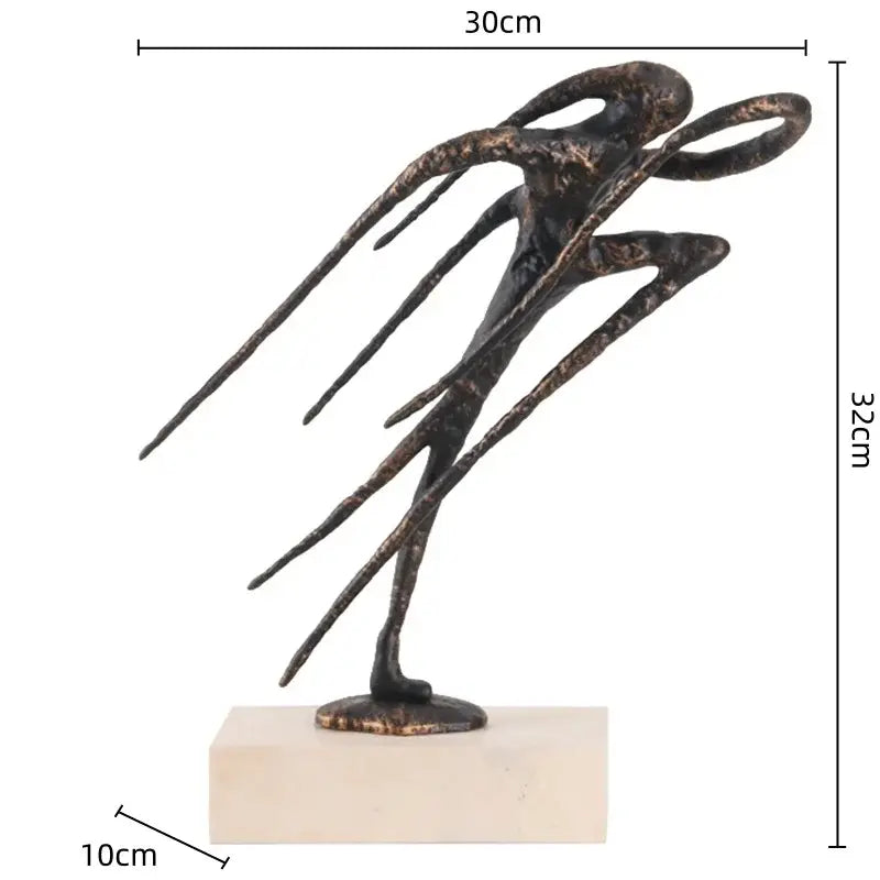 Bronze-colored geometric abstract face sculpture with elongated limbs on beige base for living room decor
