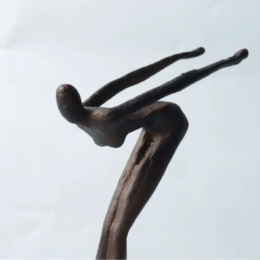 Bronze-colored abstract diving sportsman metal sculpture in mid-air pose for living room decor