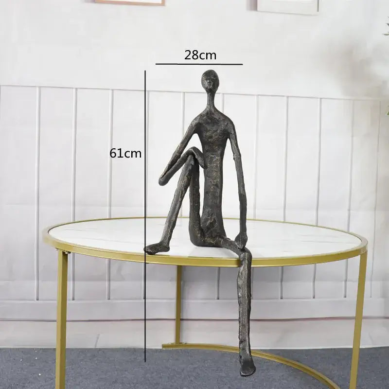A sleek dark bronze abstract metal human sculpture with elongated limbs for living room decor by decorbites